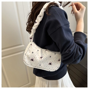 Détail d'un sac blanc avec imprimé ours et bandoulière à volants sur un mannequin