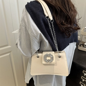 Sac bandoulière crème élégant avec boucle en cristal et bandoulière sur mannequin