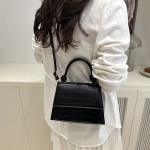 Classic black crocodile pattern trapezoid crossbody bag shown with minimalist styling