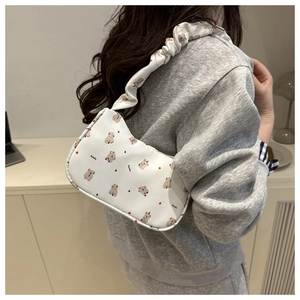 Détail du sac croissant blanc avec imprimé koala et bandoulière froncée au design chic