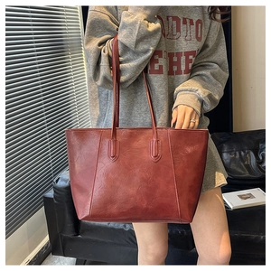 Lifestyle shot of bordeaux red textured leather tote bag with long shoulder straps