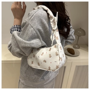 Détail du sac hobo blanc avec imprimé ours et poignées à nœuds froncés