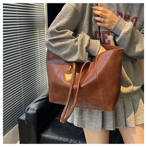 Close-up of vintage brown tote bag with premium leather texture and long shoulder straps