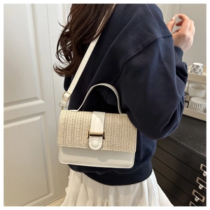 Dettaglio della trama in paglia e pelle bianca su una borsa a tracolla alla moda