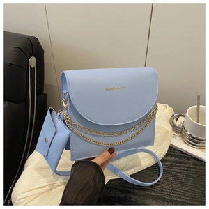 Detail of light blue crossbody bag with gold chains and matching coin purse charm