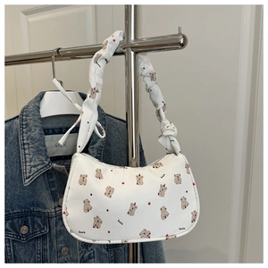 Détail de la bandoulière froncée et de l'imprimé koala sur le sac à main blanc