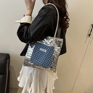 Silver sequin tote bag with a blue polka dot pocket and a slim shoulder strap