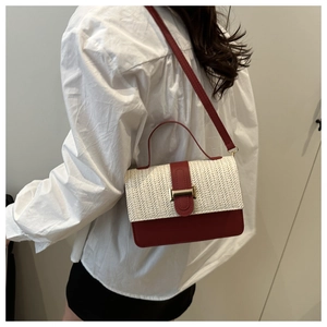 Dettaglio borsa a tracolla bicolore con trama in paglia beige e pelle rosso scuro