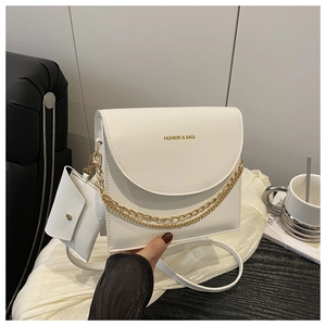Close-up of white minimalist flap crossbody bag with gold chain and small pouch