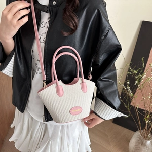 Chic pink and beige woven bucket bag with pink leather trim shown on model