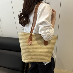 Large straw tote bag with brown leather straps and pink mesh bow for daily commute