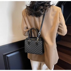 Chic small square crossbody bag with grey letter print and gold details on model