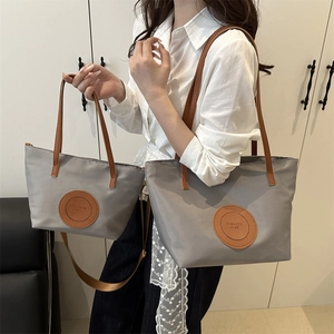 Minimalist grey tote bag set with brown leather straps shown on model for daily style