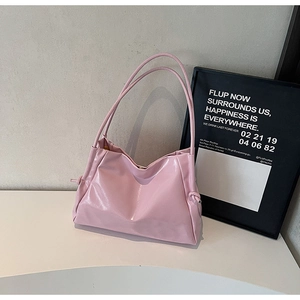 Detail showing the glossy light pink texture and unique knotted side design of the tote bag