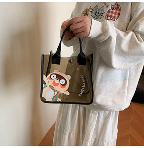 Détail du sac cabas en PVC marron avec motif dessin animé et anses en sangle noire