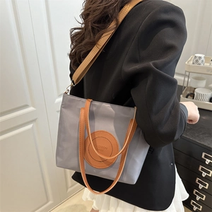 Minimalist grey nylon tote bag with contrast leather handles and fashion letter patch