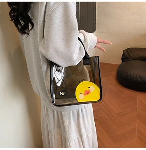 Détail du sac fourre-tout en PVC translucide avec imprimé canard jaune et anses noires