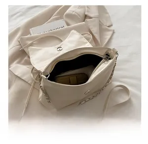 Détail de l'intérieur spacieux d'un sac à bandoulière en cuir blanc cassé à rabat