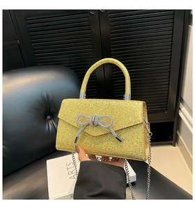 Vue détaillée des paillettes jaunes et du nœud en cristal sur ce sac à main chic