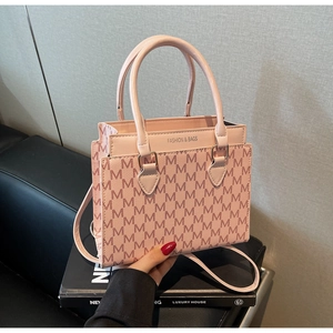 Pink fashion bag detail with M letter monogram pattern and accordion pleated side design