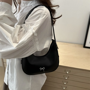 Minimalist black crescent hobo bag with silver bow detail for elegant shoulder wear