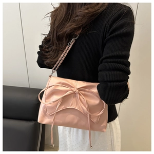 Gros plan d'un sac bandoulière rose en cuir PU avec un grand nœud et une bandoulière