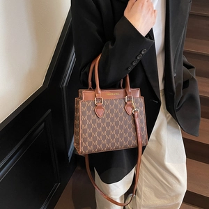Vintage brown square crossbody bag with M-pattern print and gold hardware detail