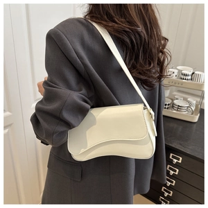 Close-up of stylish beige underarm bag with unique wave design and sleek leather texture