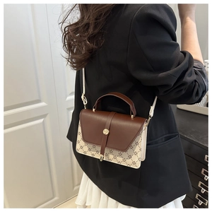 Chic retro small square bag with brown leather and floral pattern worn over the shoulder