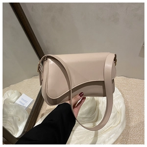 Detail of minimalist cream saddle bag with wide strap and elegant metal buckle