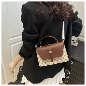 Detail of color-block flap bag with geometric print, top handle, and metallic buckle