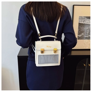 Dettaglio mini zaino in pelle bianca con chiusura dorata e rete grigia sulla modella