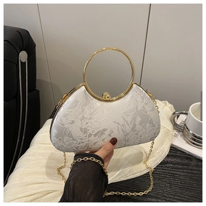 Detail der eleganten beigen Abendtasche mit floraler Stickerei und goldenem Metallgriff