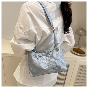 Detail of light blue lace bucket bag with 3D butterfly appliqués and pearl drawstring