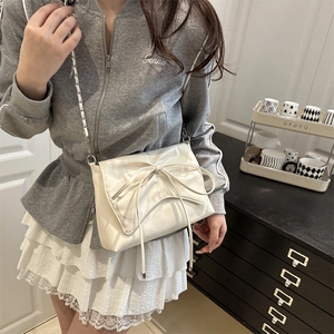 Sac à bandoulière chic en cuir crème avec grand nœud et bandoulière en chaîne argentée