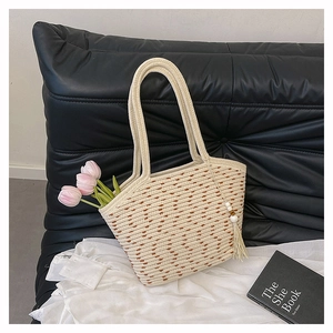 Detail of hand-woven cream tote bag with brown textures and decorative wooden bead tassel