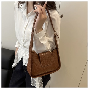Détail du sac hobo en cuir tressé marron montrant la texture Intrecciato et la bandoulière