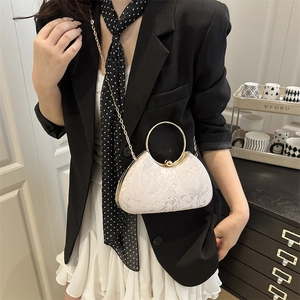 Elfenbeinweiße Handtasche mit floralem Jacquard und Goldgriffen an einem Model