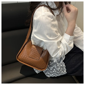 Détail de la texture en cuir PU tressé marron et du rabat magnétique du sac à bandoulière