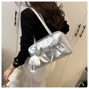 Sac à épaule argenté métallisé avec nœuds et breloque nuage duveteuse porté par le mannequin