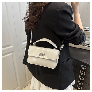Rear view of model wearing cream square crossbody bag with shiny finish and silver lock