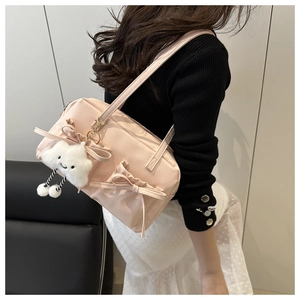 Détail du sac oreiller en nylon rose avec nœuds en ruban et peluche nuage blanc