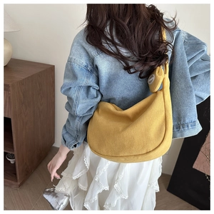 Détail du sac croissant en velours côtelé jaune avec petit porte-monnaie assorti