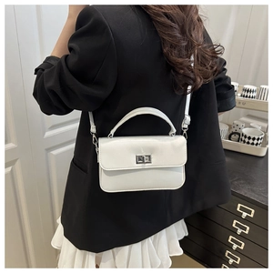 Detail of white square leather handbag featuring silver rotary metal lock and top handle