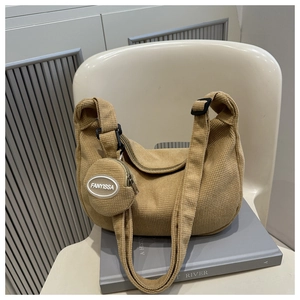 Détail de la texture du sac hobo en velours kaki avec un petit porte-monnaie rond
