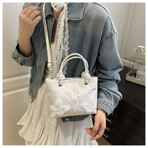 Lace crossbody bag with 3D butterfly embroidery details shown on a casual outfit