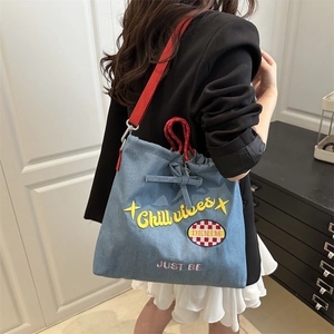 Light blue denim shoulder bag with Chill Vibes embroidery and red woven strap for daily use