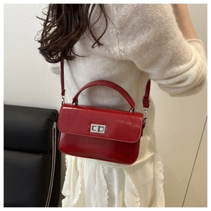Detail of red oil wax leather handbag featuring a vintage square design and silver buckle