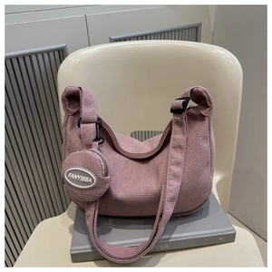 Détail du sac croissant en maille gaufrée rose poudré avec petit porte-monnaie assorti