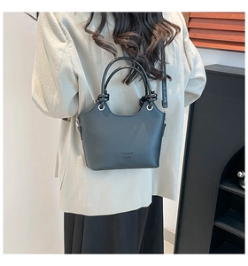 Detail of a chic black bucket bag with knot handle and Fashion H.C Bag lettering